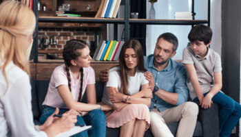 A family participates in group therapy. Learn more about these 6 family roles in addiction, here.