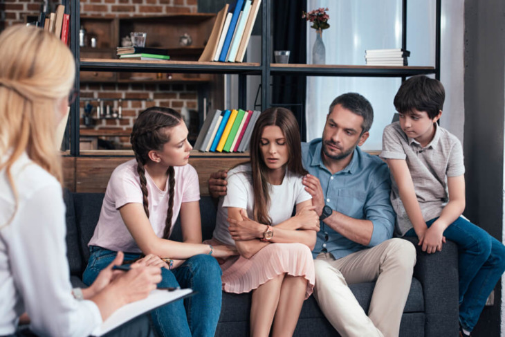 A family participates in group therapy. Learn more about these 6 family roles in addiction, here.