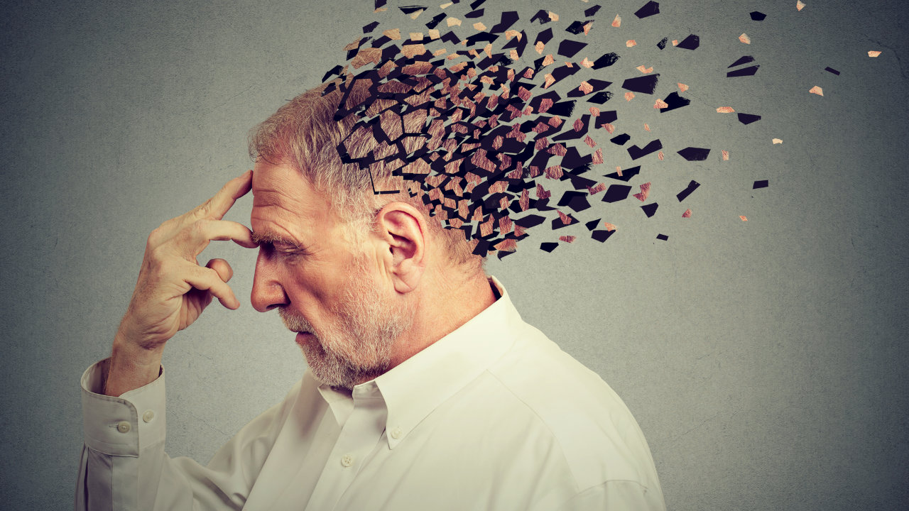 A man clutches his forehead as his cranium cracks and blows away, suggesting brain damage or cognitive decline