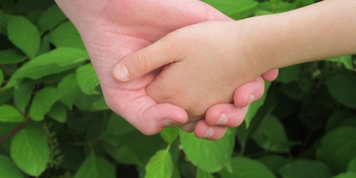 single parent holding child's hand