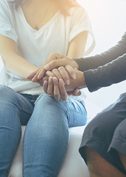 Mother holding hands with daughter while taking about mental health awareness month