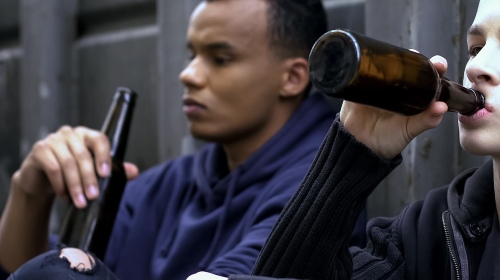 two males drinking from bottle