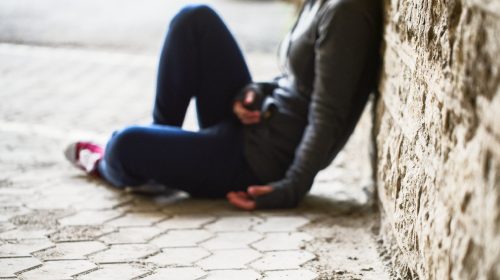 young woman leaning on wall