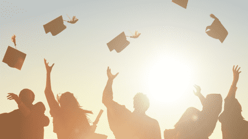 graduates throwing cap into sky