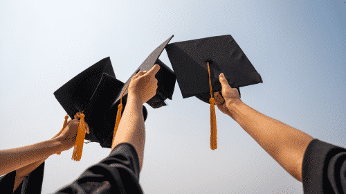 graduation caps being held up in the air