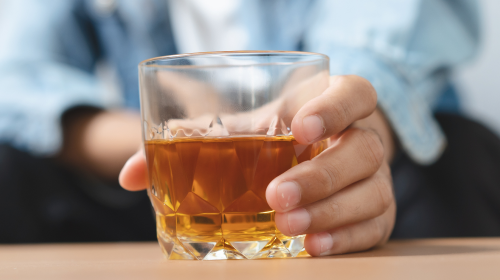 man holding glass of liquor