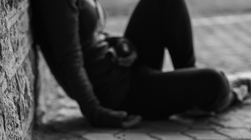 person sitting on street wall