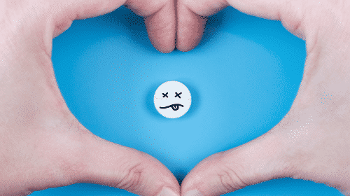 hands forming heart around consumable tablet