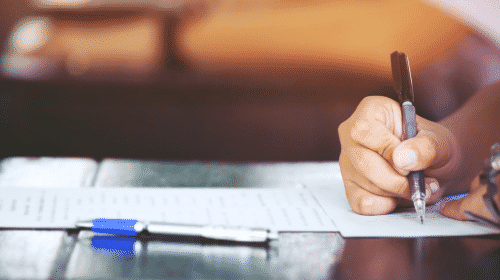 person filling out document with pen