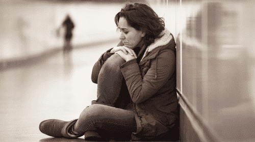 sad woman in hallway siting down