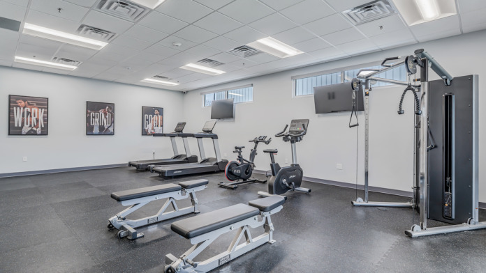 fitness room at boca recovery in Huntington Indiana. Showing two benches, two stationary bikes, and two treadmills