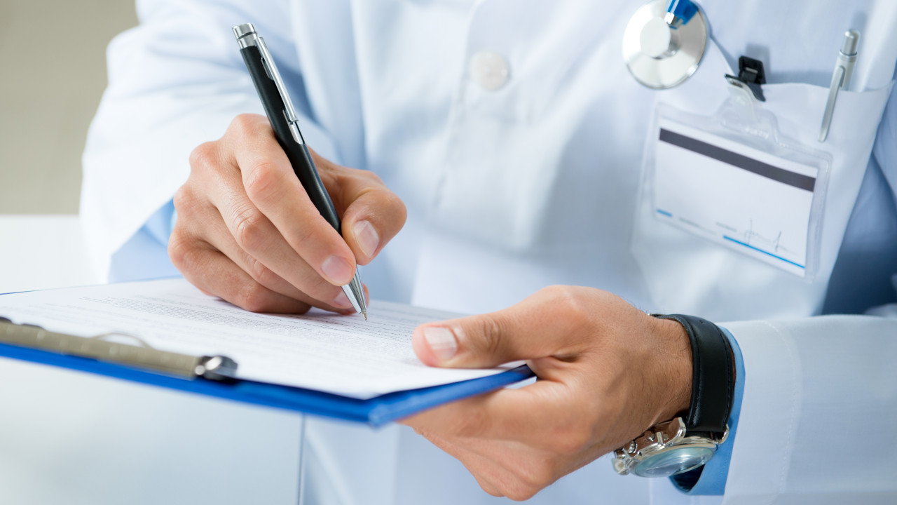 A doctor writing a prescription for gabapentin
