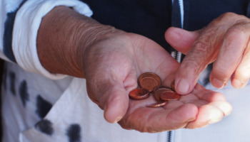 A person counting coins in their palm