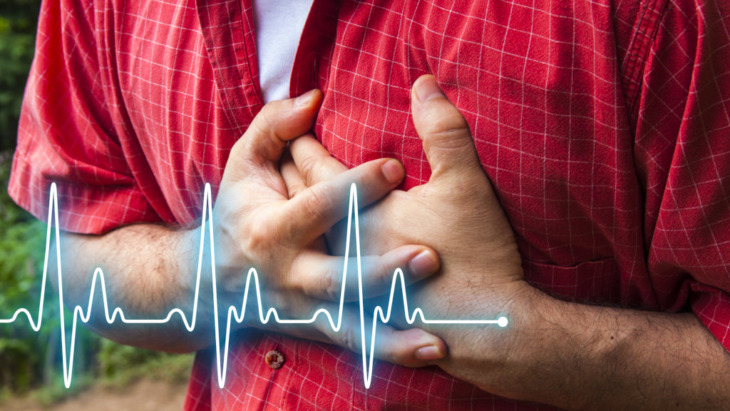 A man clutches his chest while suffering from heart issues, a common symptom of Xanax withdrawal