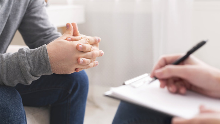 A patient speaks with a therapist during a session.