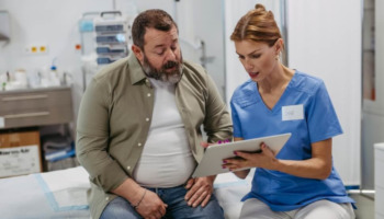 A man speaking with a doctor. Learn more about the difference between addiction, dependence, and tolerance here.