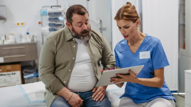 A man speaking with a doctor. Learn more about the difference between addiction, dependence, and tolerance here.