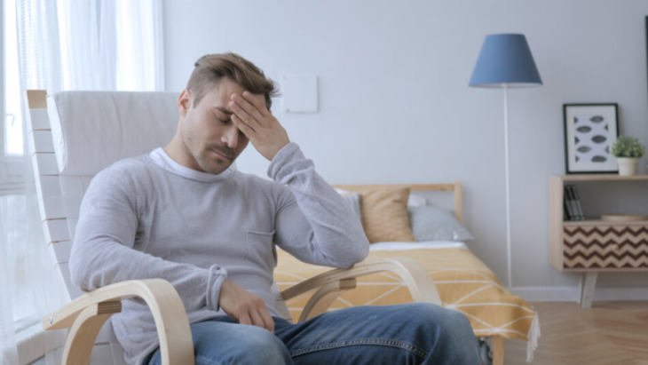 A man clutches his head. Learn more about alcohol withdrawal seizures here