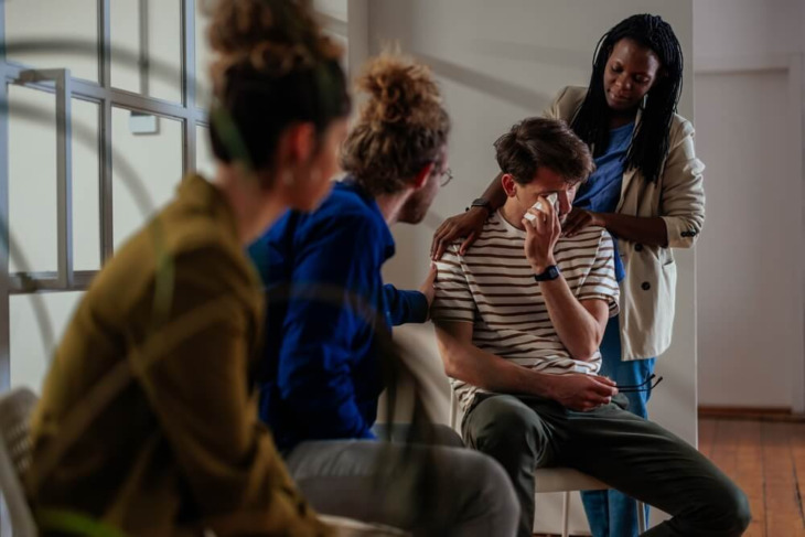 People speaking with someone at a support group. Learn more about how to talk to someone who doesn't think they have a problem or addiction, here.