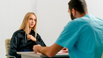 A woman speaking with a doctor. Learn more about the kratom withdrawal timeline, including symptoms and detox steps, here.