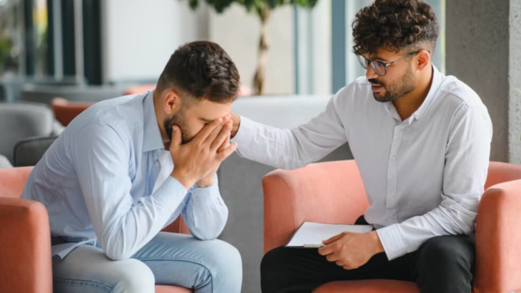 A doctor comforts a man struggling with trauma and addiction