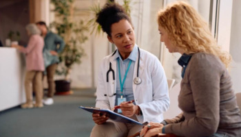 A woman speaking with a doctor at a clinic. learn more about trauma informed addiction treatment here.