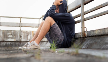 A lonely man sits on the ground, clutching his head. Learn more about how to talk to an addict and when substance use becomes a substance use disorder, here.