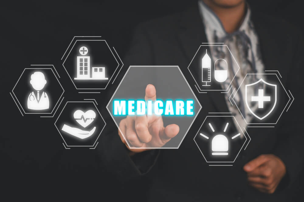 A man presses a graphic labelled "Medicare". Learn more about if medicare covers rehab for addiction treatment here