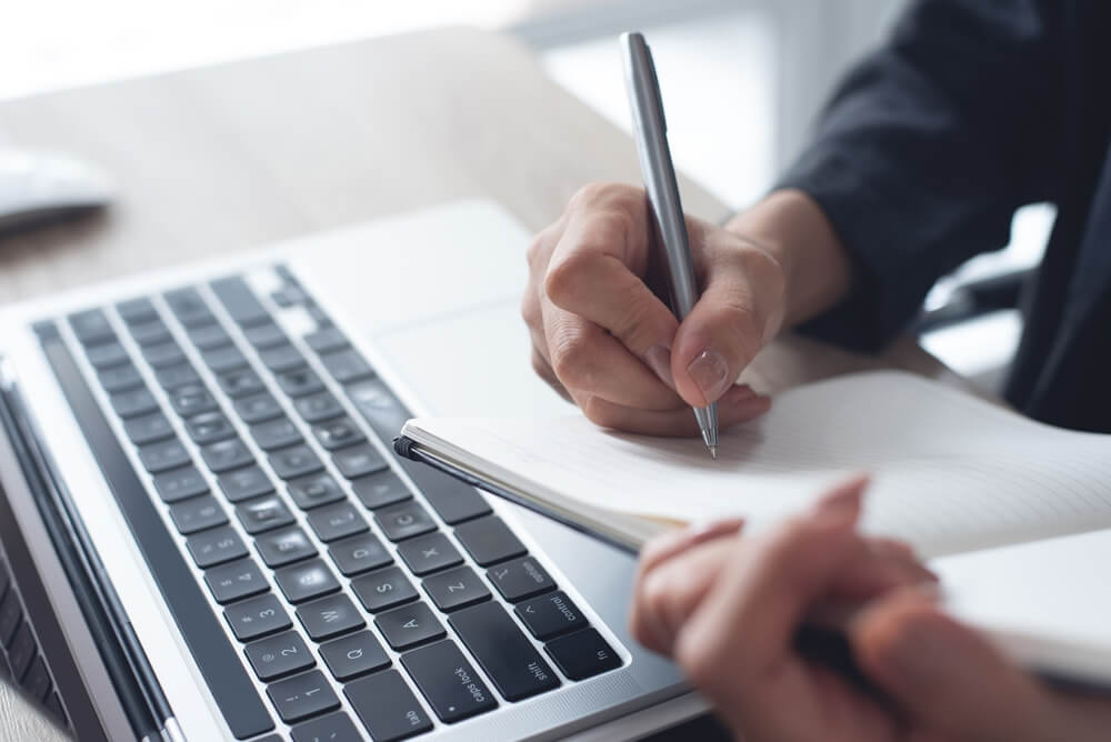 Someone writing a checklist while sitting at a laptop. Learn more about how to prepare for rehab here.