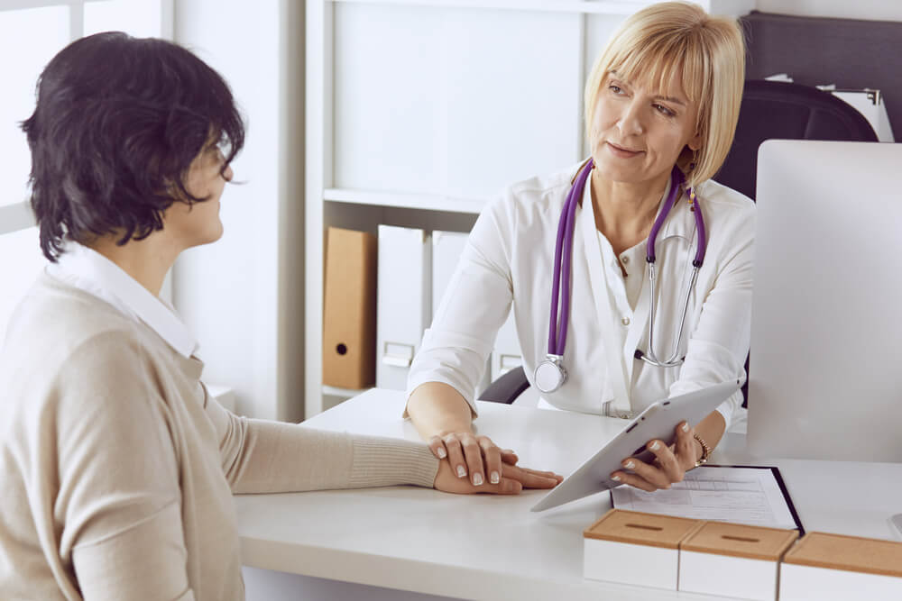 A doctor speaks with a patient. Learn more about how to taper off alcohol safely here.