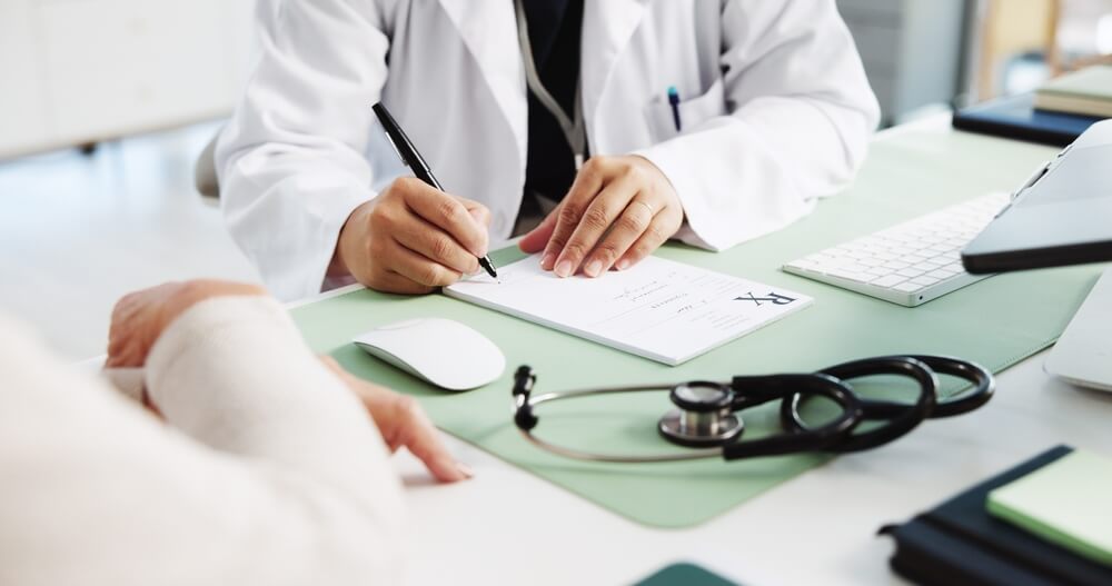 A doctor writing a prescription. Learn more about prescription drug addiction here