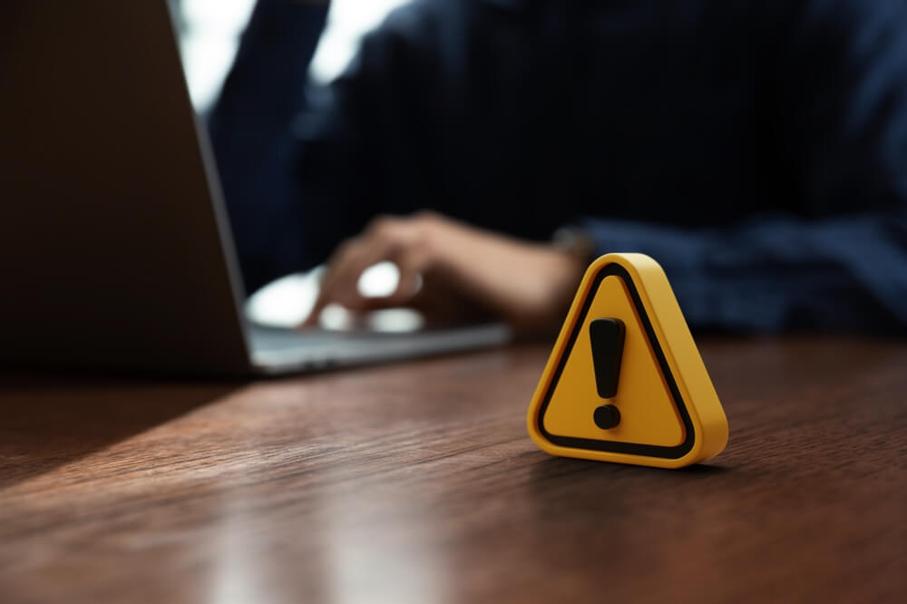 A warning sign sitting atop a desk. Learn more about relapse warning signs in addiction recovery here.