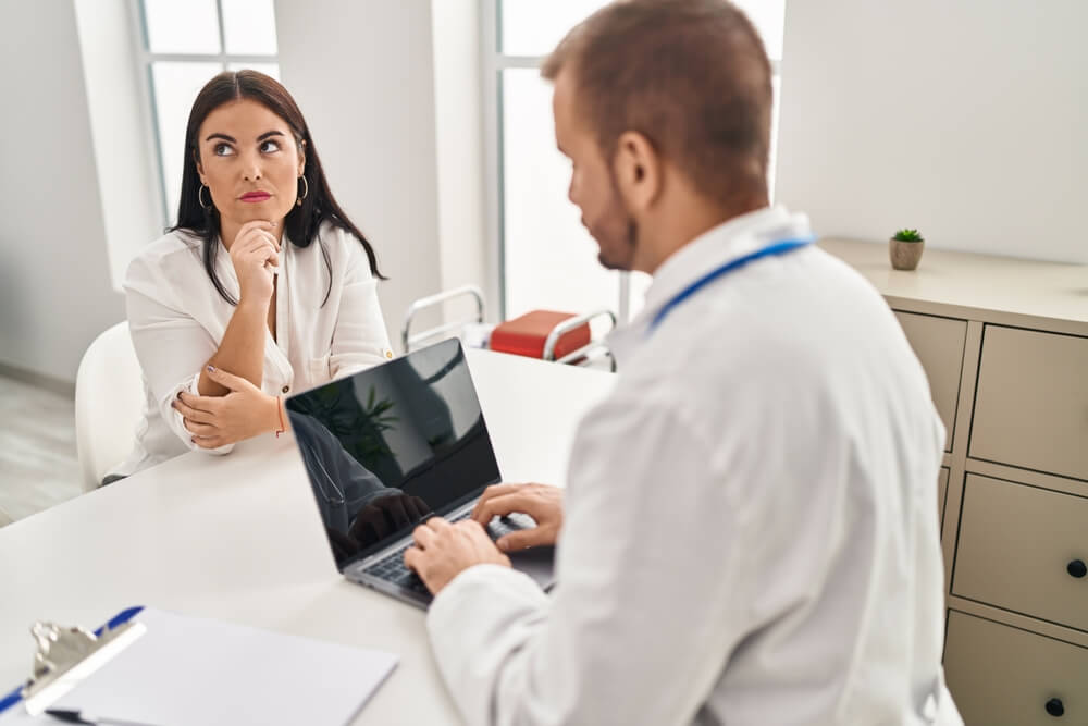 A doctor speaks with a thoughtful patient. Learn more about what happens in rehab here