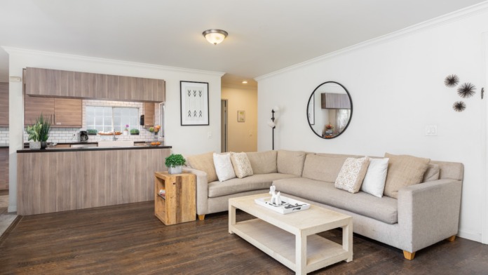 Interior common space with open-concept kitchen, beige sectional sofa, dining area, and modern furnishings