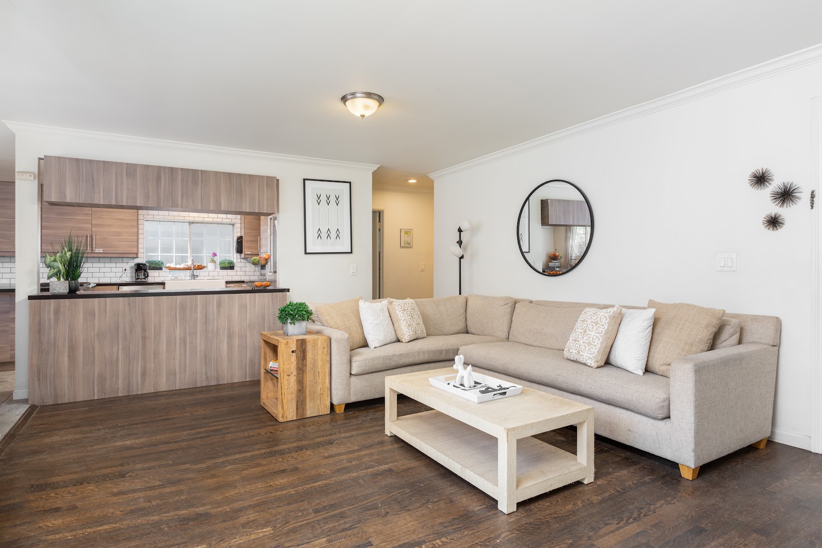 Interior common space with open-concept kitchen, beige sectional sofa, dining area, and modern furnishings