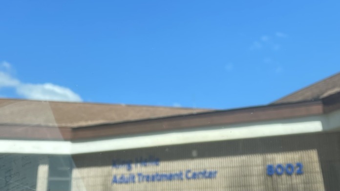 Exterior close-up of Adult Treatment Center building sign and roof line against blue sky