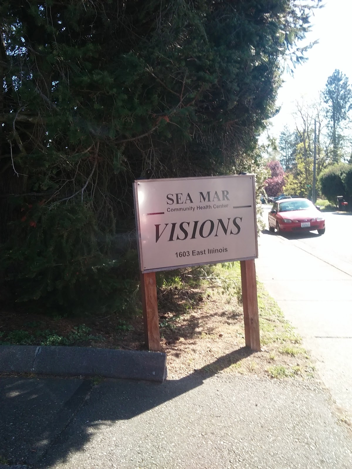 Exterior signage for Sea Mar Visions at 1603 East Illinois with facility driveway and parked vehicles visible