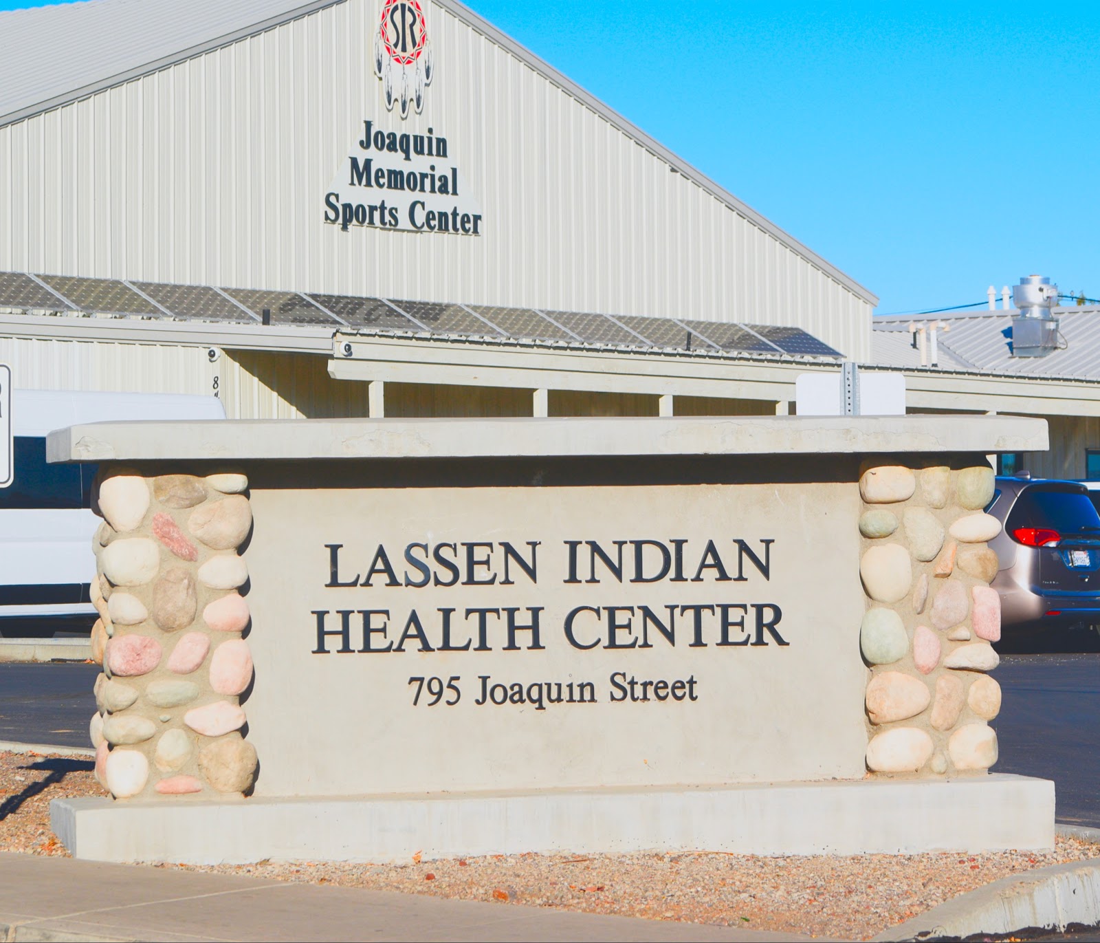 Exterior view of Lassen Indian Health Center sign with stone pillars at facility entrance on Joaquin Street