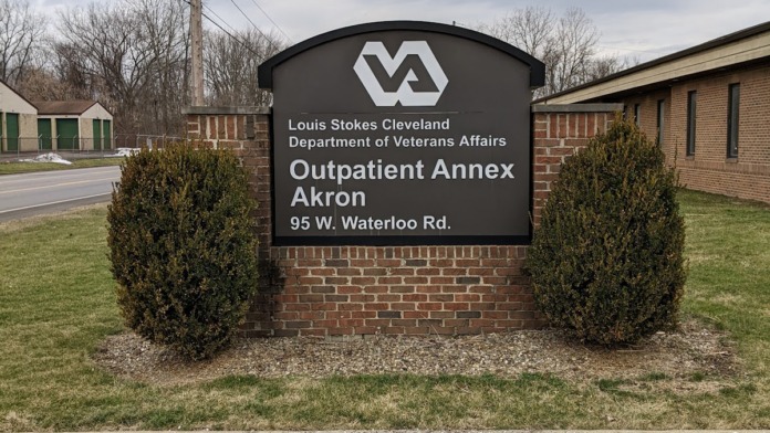 Exterior sign for Louis Stokes Cleveland Department of Veterans Affairs Outpatient Annex Akron at 95 W. Waterloo Rd with landscaping