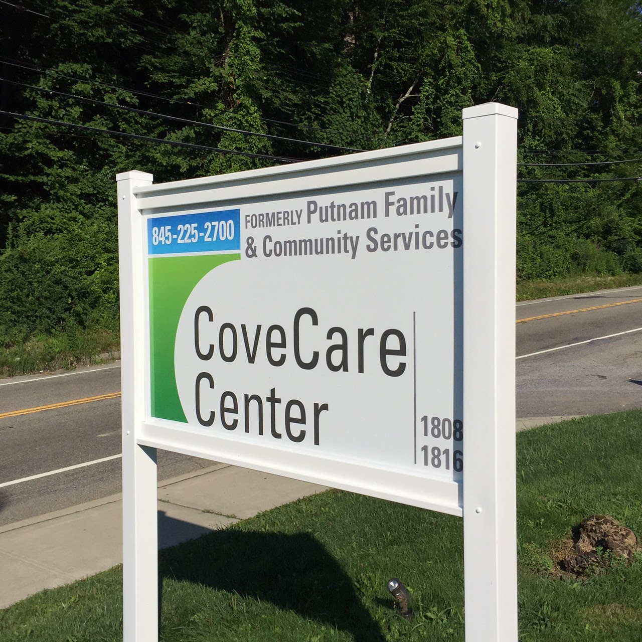 Exterior signage for CoveCare Center showing facility name, contact information, and address with landscaped grounds