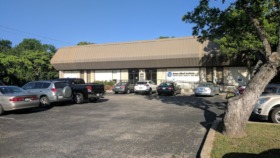 Exterior view of Seton Mind Institute building with main entrance, parking lot with multiple vehicles, and landscaping