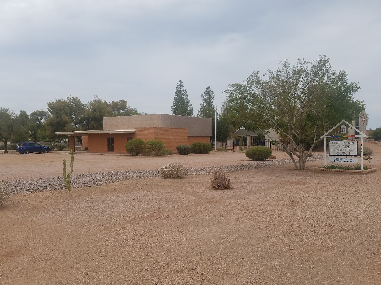 Exterior view of treatment facility with orange and tan buildings, parking area, landscaping, and signage on desert grounds