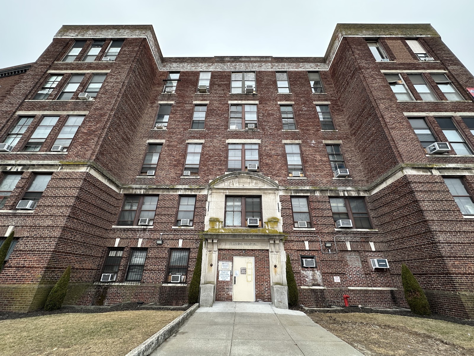 Exterior view of historic brick medical center building with central entrance and symmetrical architectural design
