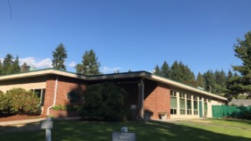 Exterior view of main treatment facility building with brick construction, wrap-around porch, manicured lawn, and mature trees