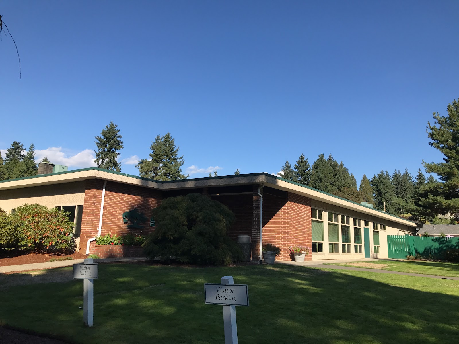 Exterior view of main treatment facility building with brick construction, wrap-around porch, manicured lawn, and mature trees