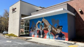 Exterior view of Families First treatment center entrance with modern architecture, signage, and colorful community mural on building wall