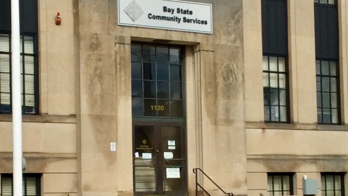 Exterior view of Bay State Community Services building entrance with signage, landscaping, and entrance stairs