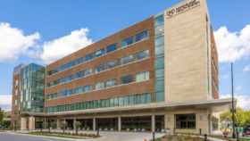 Exterior view of modern healthcare facility with brick and stone facade, multiple floors, and main entrance