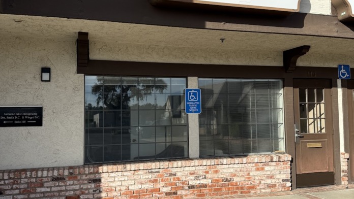 Exterior storefront showing Lumen Health Services main entrance with prominent signage, brick base, and accessible parking indicator