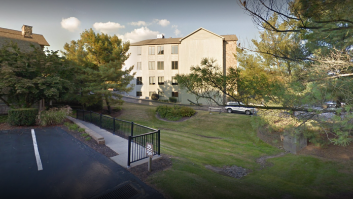 Exterior view of multi-story treatment facility with parking area, landscaped grounds, and main building entrance